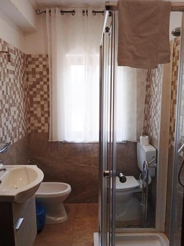 a bathroom with a shower and a toilet and a sink at B&B Nonno Pino in Maierà