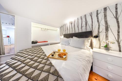 een slaapkamer met een bed met een dienblad met eten erop bij Mbird Estoril Riviera Flat 2 in Estoril
