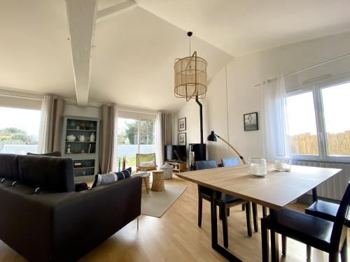 un salon avec une table et des chaises de salle à manger dans l'établissement L Oiseau, à Saint-Hilaire-de-Riez
