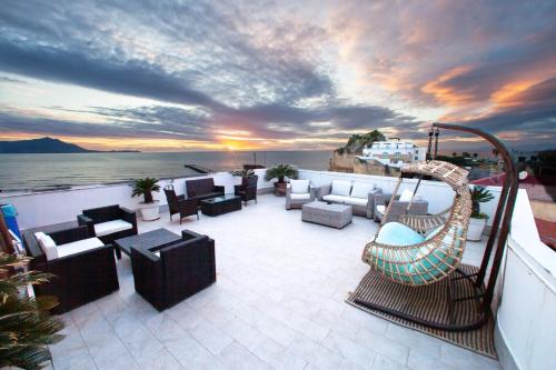 a patio with couches and chairs on a balcony at Naro Suites and Rooms in Bacoli