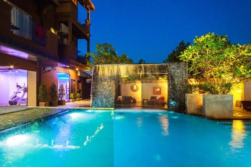 a swimming pool in front of a house at night at Mazi Design Hotel by Kalima in Patong Beach
