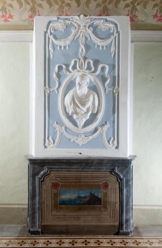 a fireplace with a painting of a bust above it at Hotel Palazzo di Valli in Siena