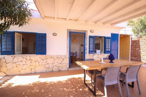 a patio with a wooden table and chairs at Dimore di mare - Beachfront Apartments in Santa Flavia
