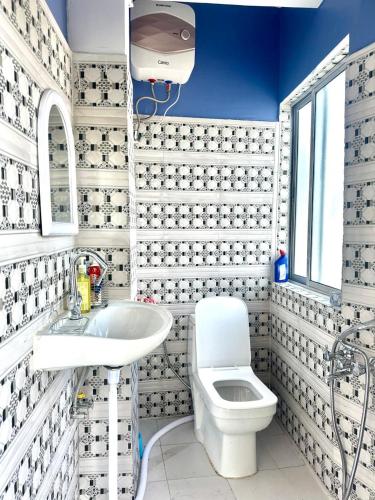 a white bathroom with a toilet and a sink at Mountain View homestay in Darjeeling