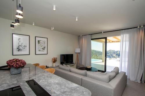 ein Wohnzimmer mit Sofa und Tisch in der Unterkunft Villa Lume Nea Skioni by Halkidiki Villas in Nea Skioni