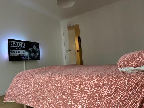 - une chambre dotée d'un lit avec une horloge murale dans l'établissement Appartement neuf proche de Orly, à Chevilly-Larue