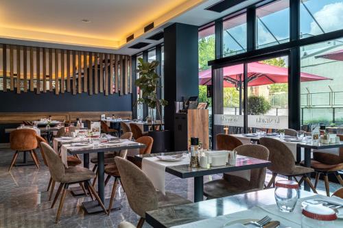 a restaurant with tables and chairs and windows at The Plaza Hotel Edirne in Edirne
