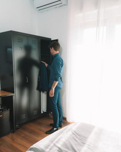 a man is looking into a cabinet in a bedroom at TRAVEL STATION Bedandbreakfast in Bari