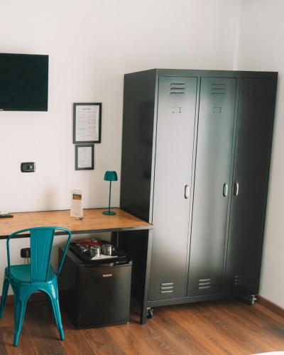a desk with a blue chair next to a cabinet at TRAVEL STATION Bedandbreakfast in Bari