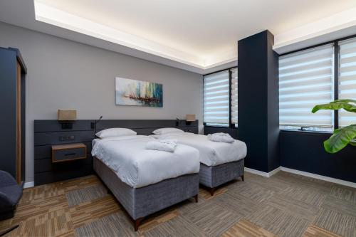two beds in a bedroom with blue walls at The Plaza Hotel Edirne in Edirne