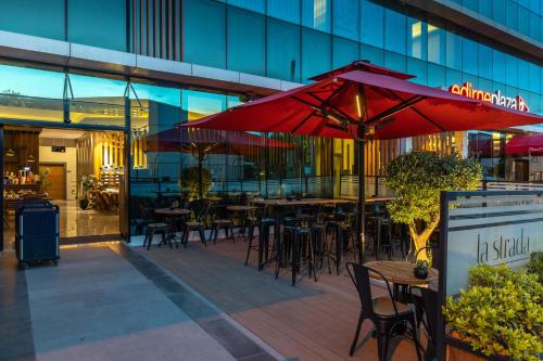 an outdoor patio with tables and chairs and umbrellas at The Plaza Hotel Edirne in Edirne