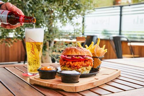 a sandwich and fries on a table with a glass of beer at The Plaza Hotel Edirne in Edirne