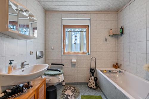 a bathroom with a sink and a tub and a toilet at Ferienwohnung Hartmann in Mittelherwigsdorf