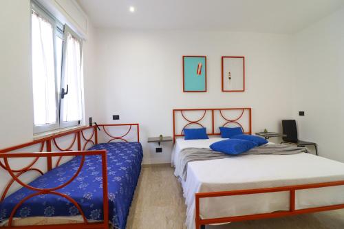 a bedroom with two beds with blue pillows at Casa Malika a Otranto in Otranto