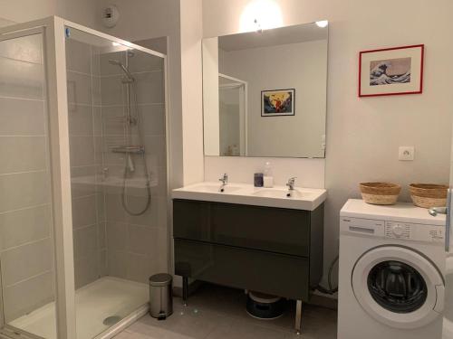 La salle de bains est pourvue d'un lavabo, d'une douche et d'un lave-linge. dans l'établissement Appartement Gujan Mestras premier étage, à Gujan-Mestras