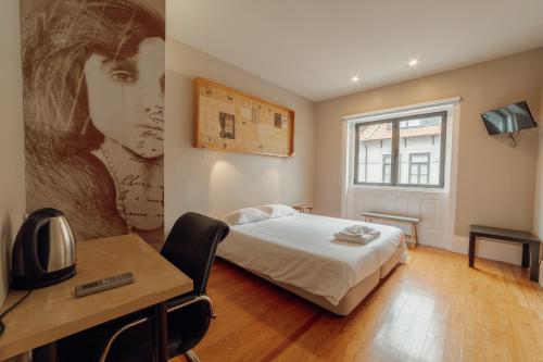 a bedroom with a bed and a desk and a window at Boutique Suites by Hosty in Porto