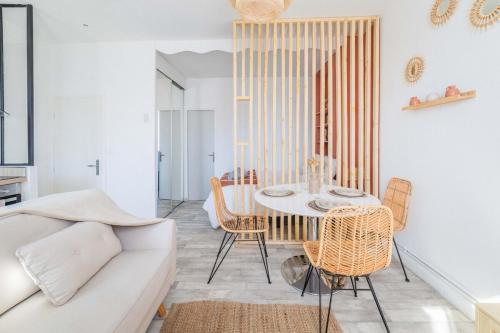 un salon avec une table, des chaises et un canapé dans l'établissement Le Boheme Terracotta - Proche du centre hospitalier, à Brive-la-Gaillarde