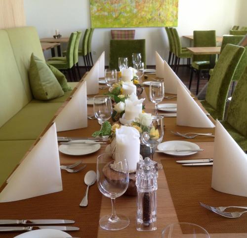 einen langen Tisch mit Weingläsern und Tellern darauf in der Unterkunft Hotel Rheingold in Gailingen