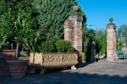 a stone planter with plants in it on a sidewalk at Hotel Palazzo di Valli in Siena