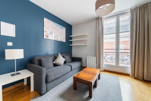 un salon avec un canapé et une table dans l'établissement 406- Appartement spacieux face jardins des Plantes, à Paris