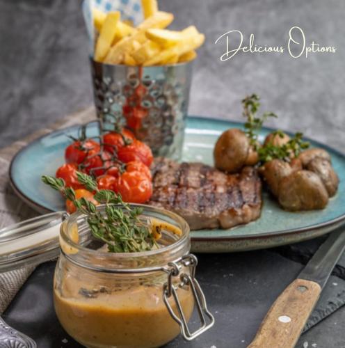 a plate of food with meat and vegetables and a jar of sauce at The Lansdowne Hotel in Dublin