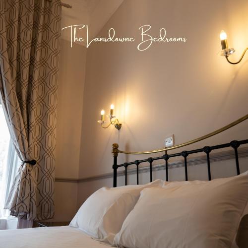 a bedroom with a bed with white sheets and a window at The Lansdowne Hotel in Dublin