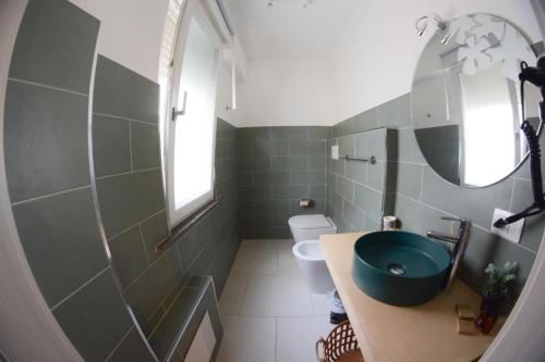 a bathroom with a green sink and a toilet at Villa Vera in Salerno