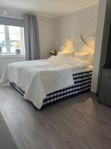 a bedroom with a bed with white sheets and a window at Bollnäs bed and breakfast in Bollnäs