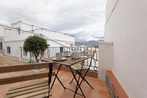 Un balcón con una mesa y sillas en un tejado. en Comeback LA BOHEME, en Salobreña