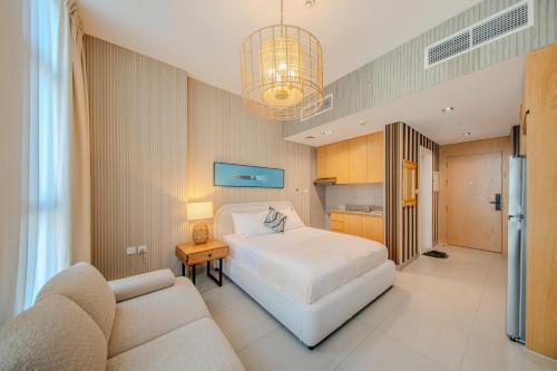a bedroom with a white bed and a couch at The Boutique Studio at Al Mamsha, Sharjah in Sharjah Intl
