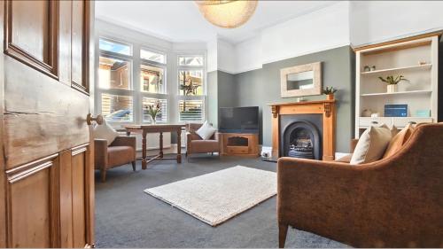a living room with a fireplace and a table and chairs at The Albany Rooms Bexhill in Bexhill