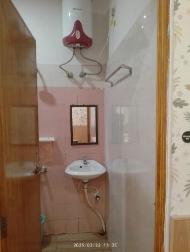 a bathroom with a sink and a red hat on the wall at Amazing Homestay in Guwahati