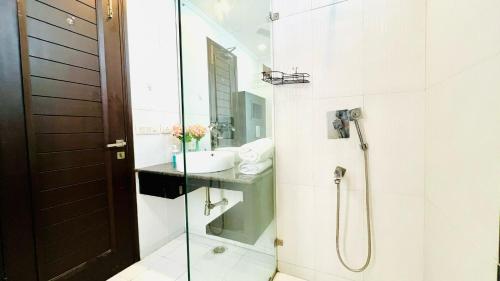 a bathroom with a shower and a sink at Olive Service Apartments - Greater Kailash in New Delhi