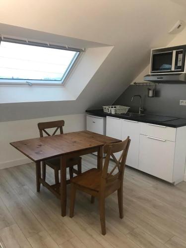 une cuisine avec une table en bois et deux chaises dans l'établissement Appartements à Saint Nazaire, parking gratuit, à Saint-Nazaire