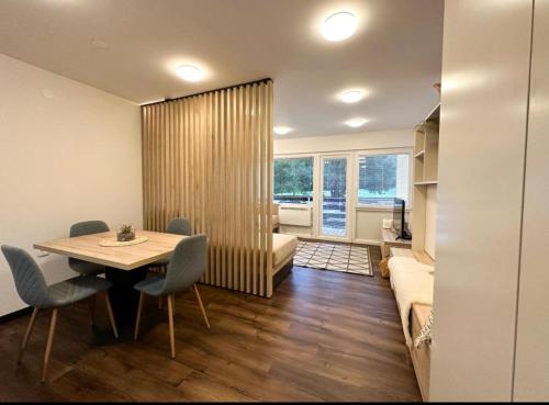 una habitación con una mesa y sillas y un sofá en Apartma Prisojnik Kranjska Gora, en Kranjska Gora
