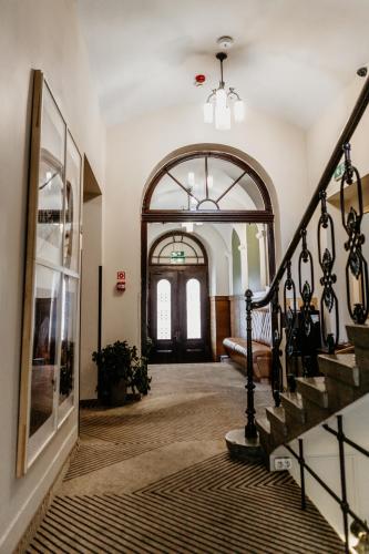 a hallway with a staircase and an archway at Hotel Yarden by Artery Hotels in Kraków