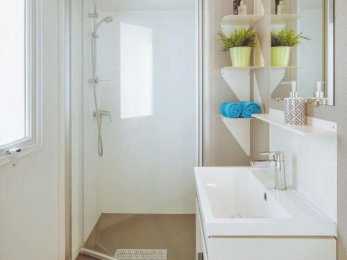 a white bathroom with a sink and a shower at Valamar Camping Lanterna - Roan in Poreč