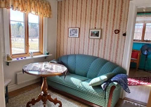 a living room with a blue couch and a table at Hus Hammerstrand in Hammarstrand