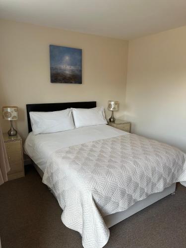 a bedroom with a large bed with a white comforter at Newent Golf Club and Lodges in Newent