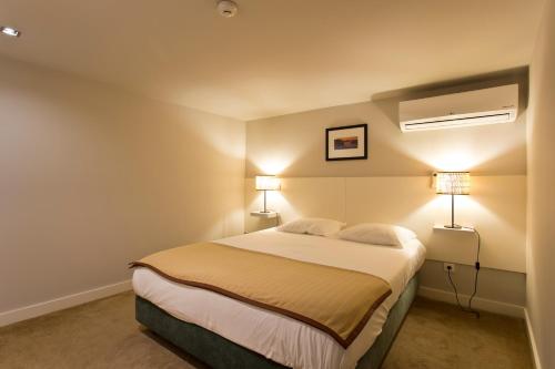 a bedroom with a large bed with two lamps at RVA - Porto Central Flats in Porto