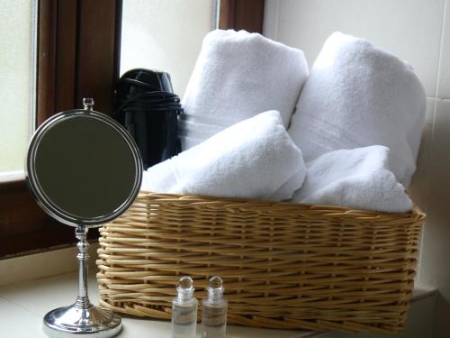 a basket of towels on a counter with a mirror at Posada 3 Valles in Liérganes