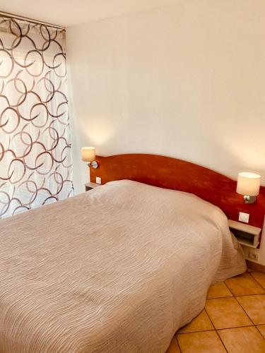 un lit avec une tête de lit en bois dans une chambre dans l'établissement Superbe T2 bord de mer belle résidence au port Argeles piscine & parking, à Argelès-sur-Mer