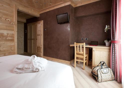 a bedroom with a bed and a desk with a bag at Hotel Funivia in Bormio