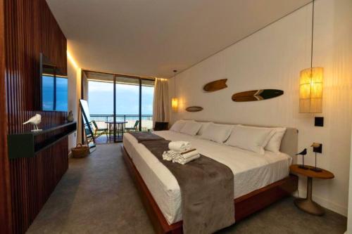 Un dormitorio con una cama con vista al mar. en Nanii Hotel, en São Miguel do Gostoso