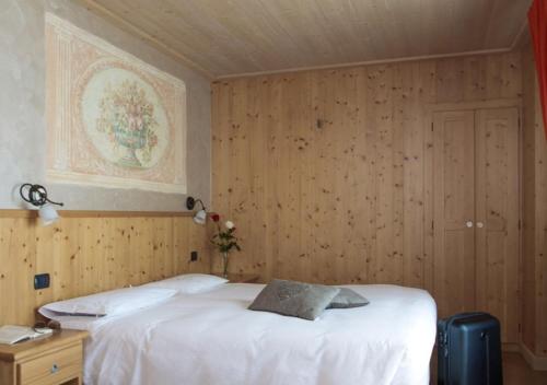 a bedroom with two beds and a painting on the wall at Hotel Funivia in Bormio