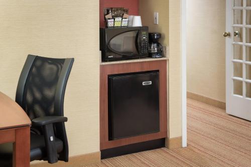 a tv and a chair in a hotel room at Courtyard Shelton in Shelton