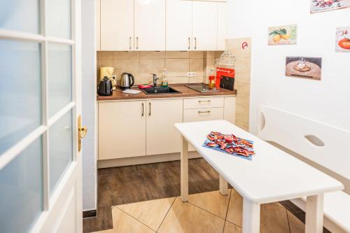 a kitchen with a white table and a white refrigerator at Villa Backstein OBO19 in Schwerin
