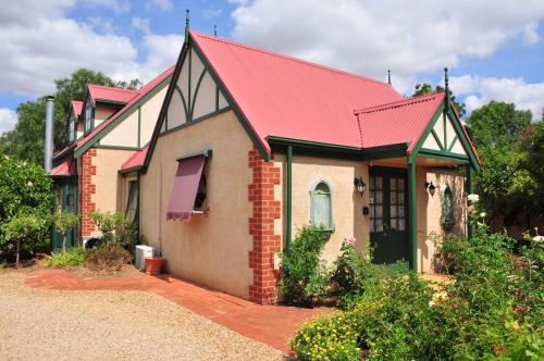 una pequeña casa de ladrillo con techo rojo en The Dove Cote, en Tanunda