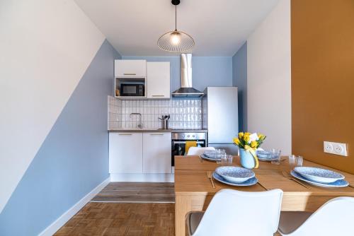 une cuisine et une salle à manger avec une table et des chaises en bois dans l'établissement Une coloc en ville 2 - 376, à Rouen