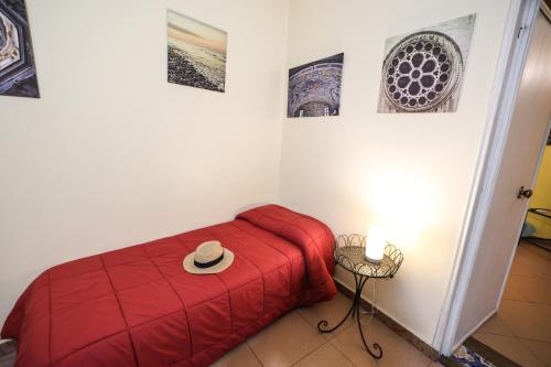 a room with a red bed with a hat on it at Antica Dimora in Palermo